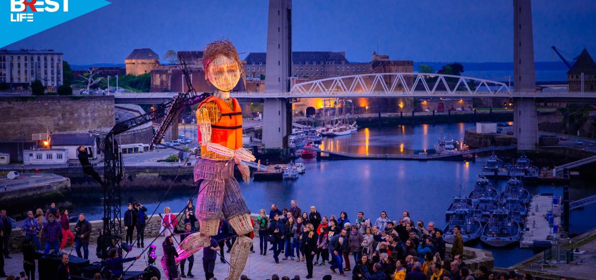 Vue de nuit des Capucins, une foule regarde une marionnette géante