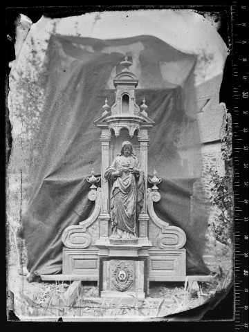 photographie d'une sculpture religieuse exposée en extérieur avec un drap tendu derrière