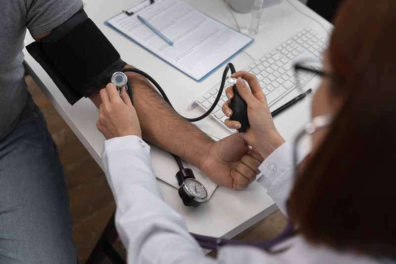 Médecin femme qui prend la tension d'un patient