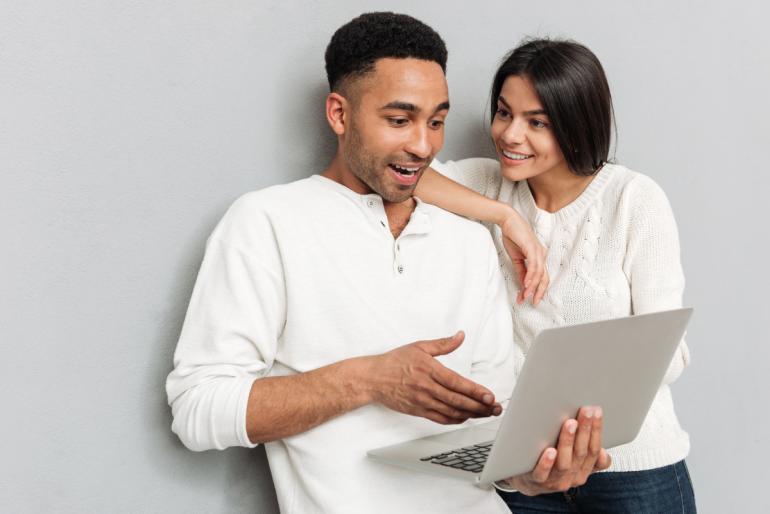 Visuel de personnes consultant un ordinateur en souriant