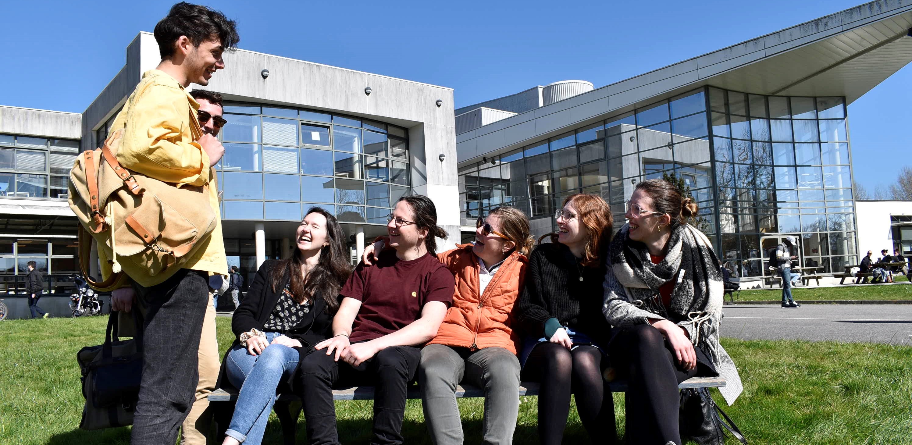 Un groupe d'étudiant.e.s rit devant le pôle