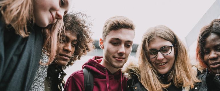 Des étudiantes et étudiants autour d'un smartphone