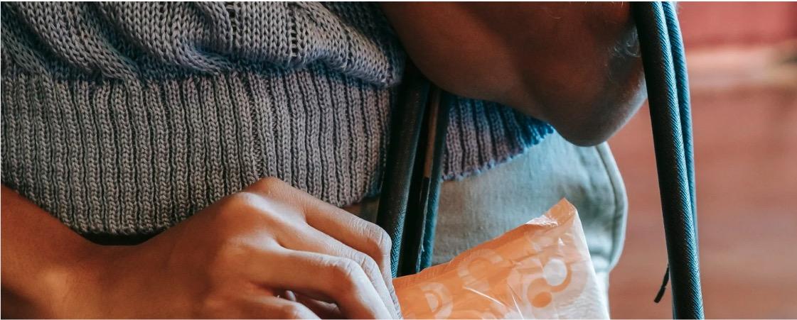 une femme prend une serviette hygiénique dans un sac à main