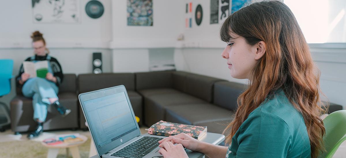 une étudiante devant son ordi portable