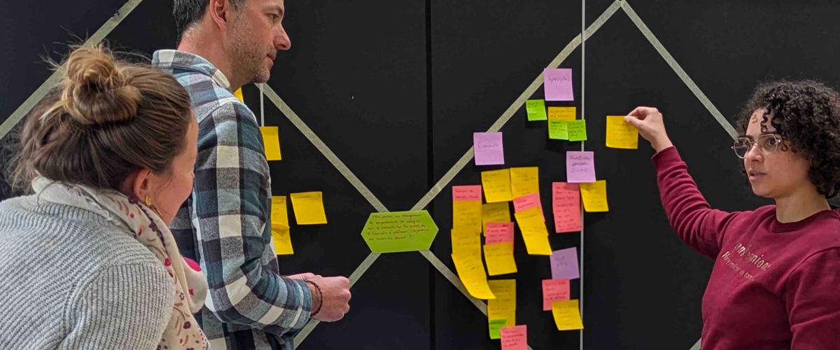 trois personnes devant tableau avec un double diamant et post-it
