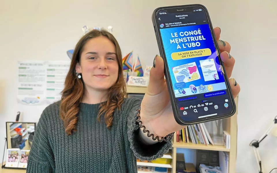 étudiante qui montre une page internet sur son téléphone portable sur le congé menstruel à l'UBO