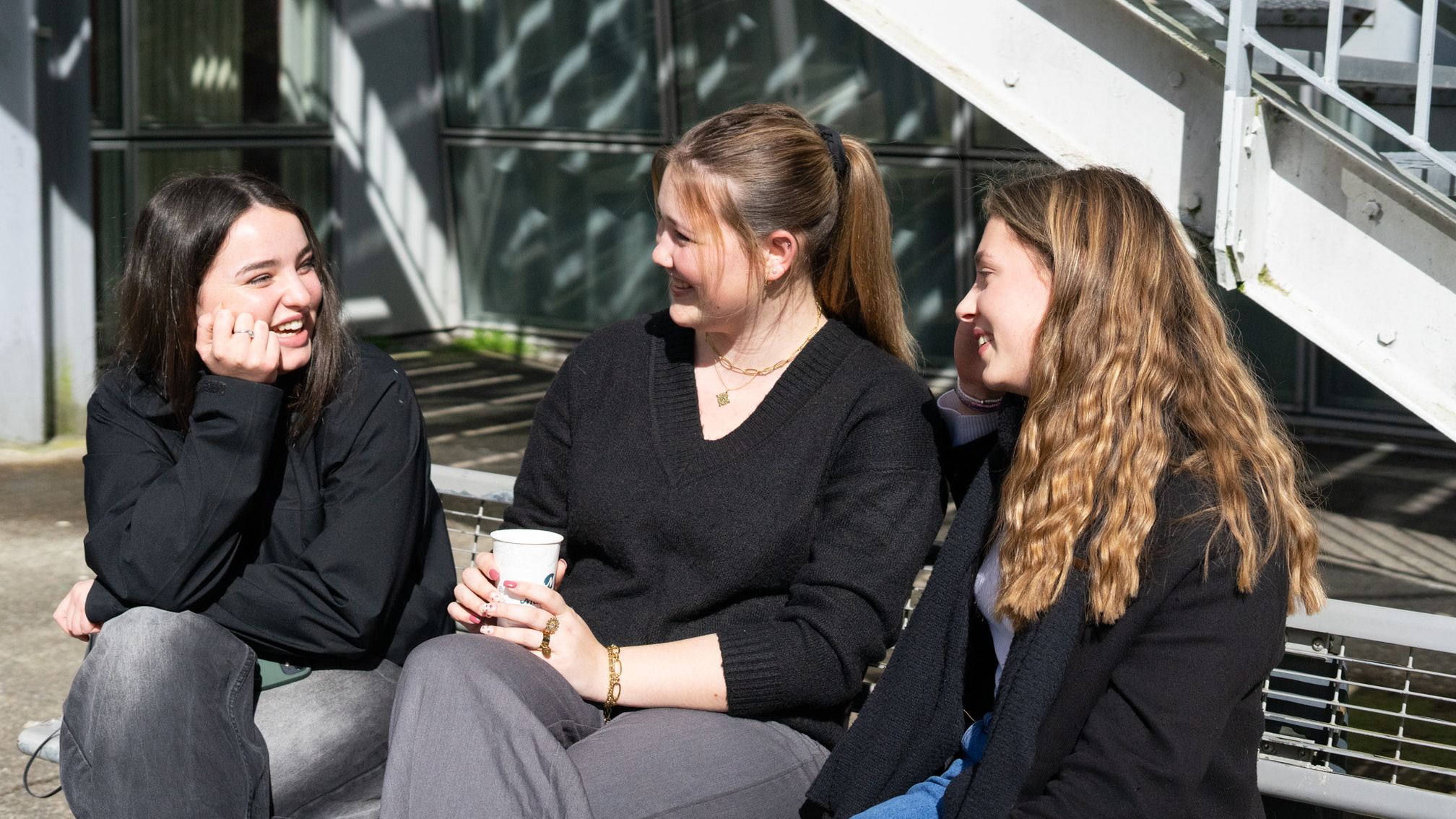 3 étudiantes discutant sur un banc