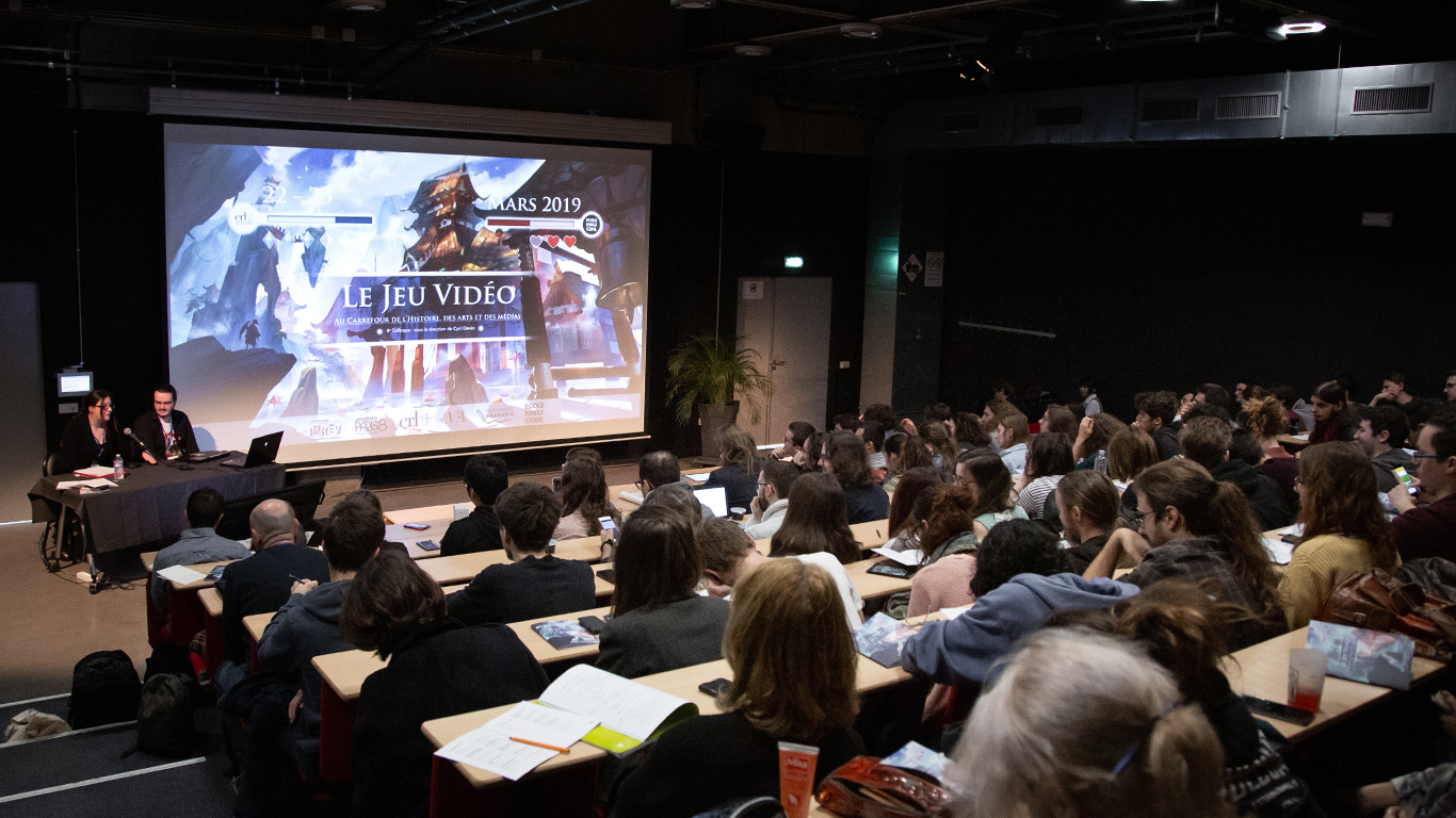 personnes assises dans un aphi devant un écran géant