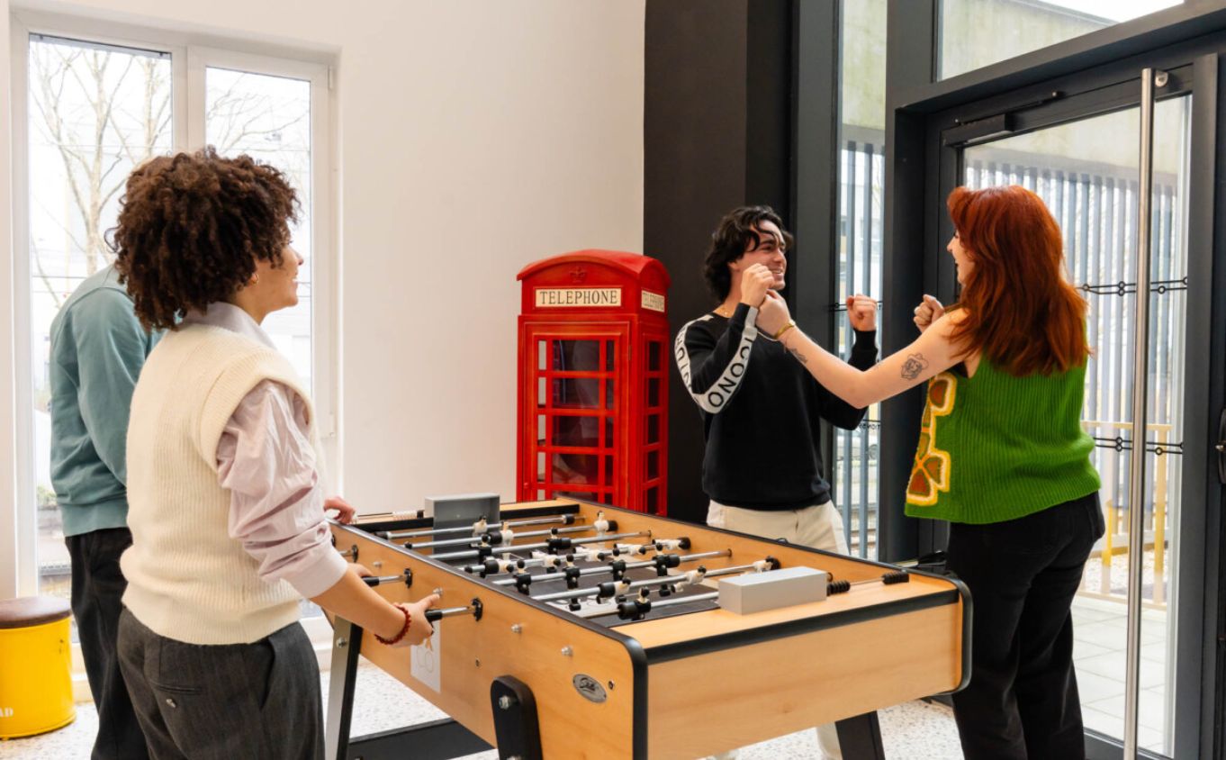 jeunes qui rigolent près d'un babyfoot